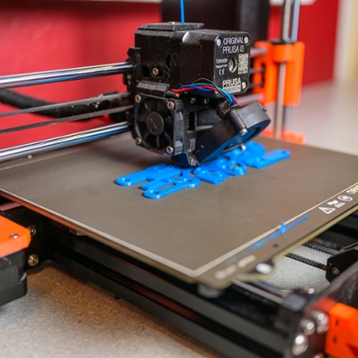 3D printer churns out plastic components.<br>